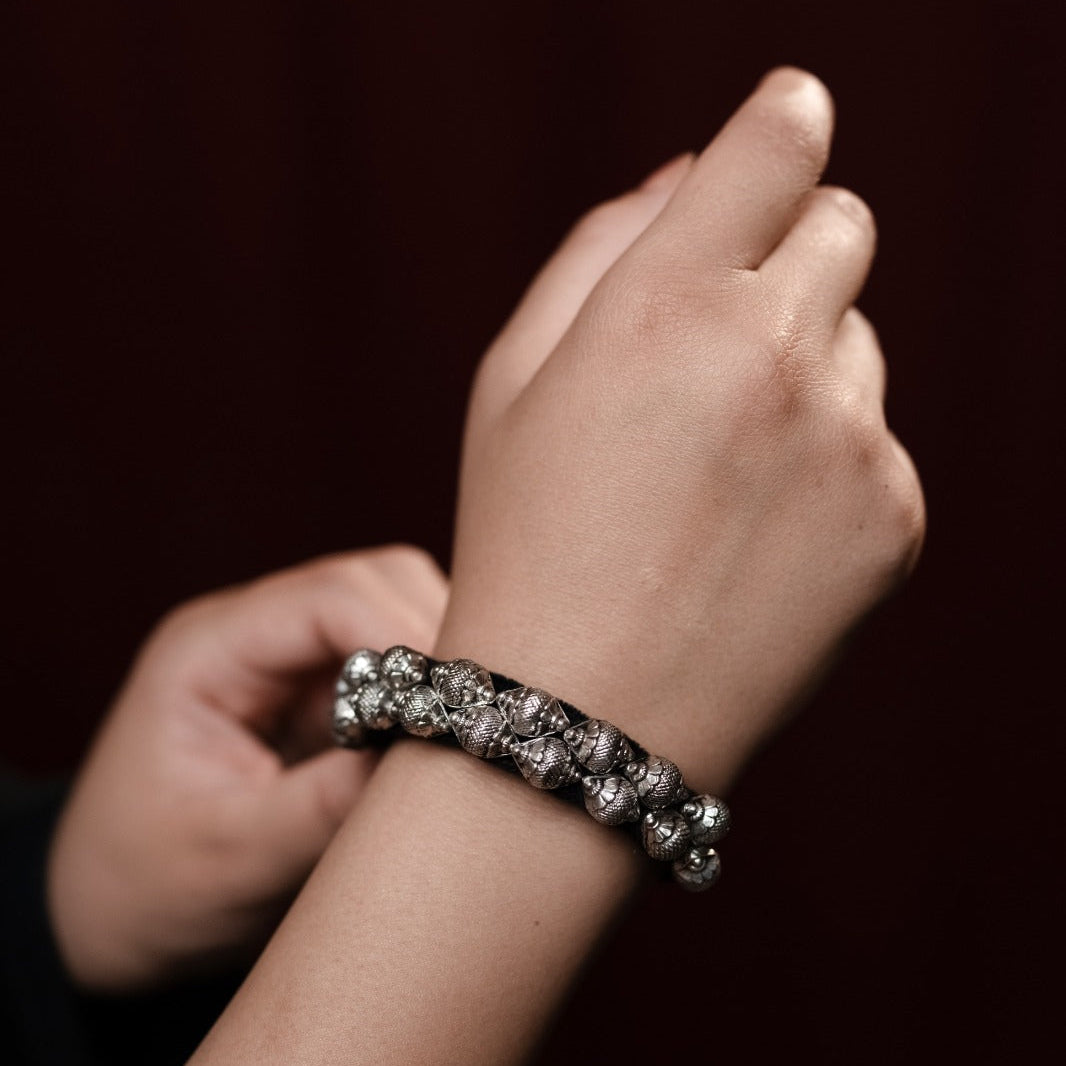 Close-up of a hand wearing a bracelet on a dark background