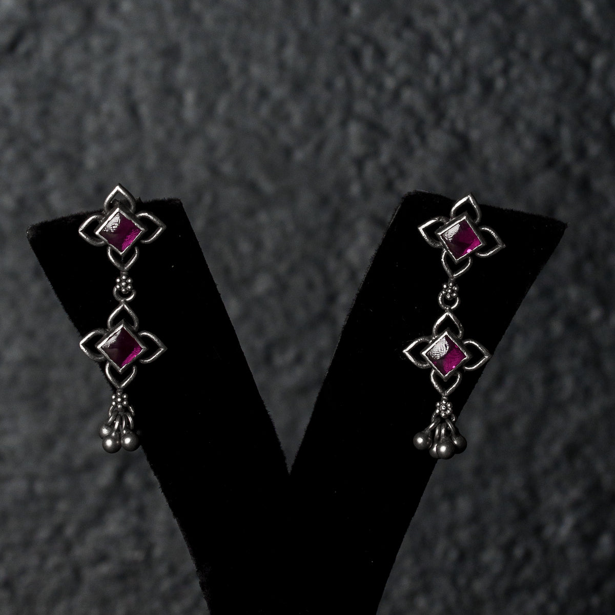 Ruvina Earrings with square pink gemstones and dangling bead details.