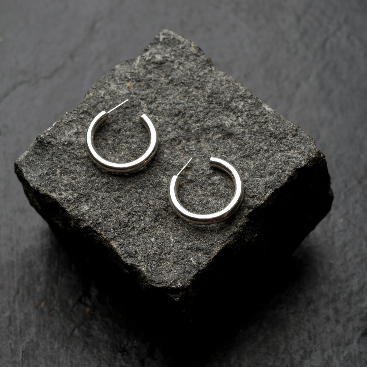 Gairi Hoops displayed on a dark textured stone block.